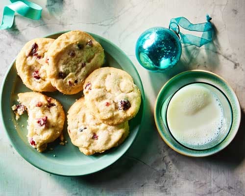 Cranberry White Chocolate Shortbread Cookies on a plate with holiday drink