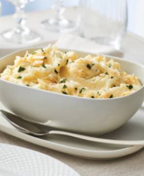 Bowl of creamy mashed potatoes with herbs